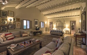 A spacious living room with a large sofa, a coffee table, and a reading area with books and a board game. - Awesome home in Vignanello with private swimming pool, can be inside or outside (Vignanello)