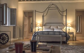 A four-poster bed with a canopy, two bedside lamps, a radiator, and a vintage carriage wheel. - Awesome home in Vignanello with private swimming pool, can be inside or outside (Vignanello)