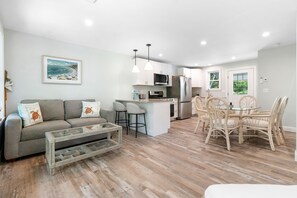 A modern kitchen with white cabinets, a stainless steel refrigerator, and a microwave. - Seaberry Woods A Nature-filled Retreat Near Camden (Hope)