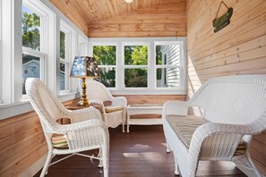 A covered porch with wicker furniture, a table, and a lamp. - Zlatibor (Camden)