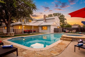 A residential backyard with a swimming pool, outdoor seating, and a wooden fence. - Private Pool & Loungers | Theater, Dry Sauna & Games (San Antonio)