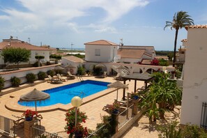 A pool area with lounge chairs, a small pool, and a view of the surrounding buildings. - LLANOS 5 APARTMENT (Cuevas del Almanzora)