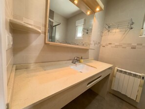 A bathroom with a sink, mirror, towel rack, and a radiator. - LLANOS 4 APARTMENT (Cuevas del Almanzora)