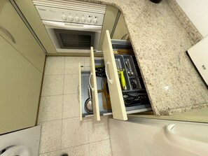Cozinha com forno embutido, pia e bancada.