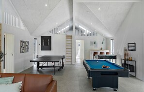 A spacious room with a pool table, a ping pong table, and a billiards table. There is a staircase leading to an upper level. - Beautiful home in Idestrup with sauna (Idestrup)