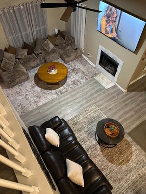 A modern living room with a black leather sofa, a round coffee table, and a fireplace. - Waterfront Retreat in Jacksonville (Jacksonville)