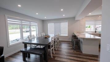 Una cocina moderna con comedor, ventanas amplias y una barra.