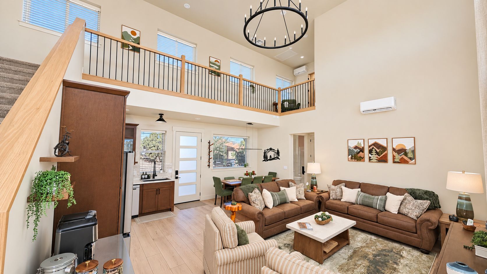A spacious living area with a high ceiling, a staircase, and a balcony.