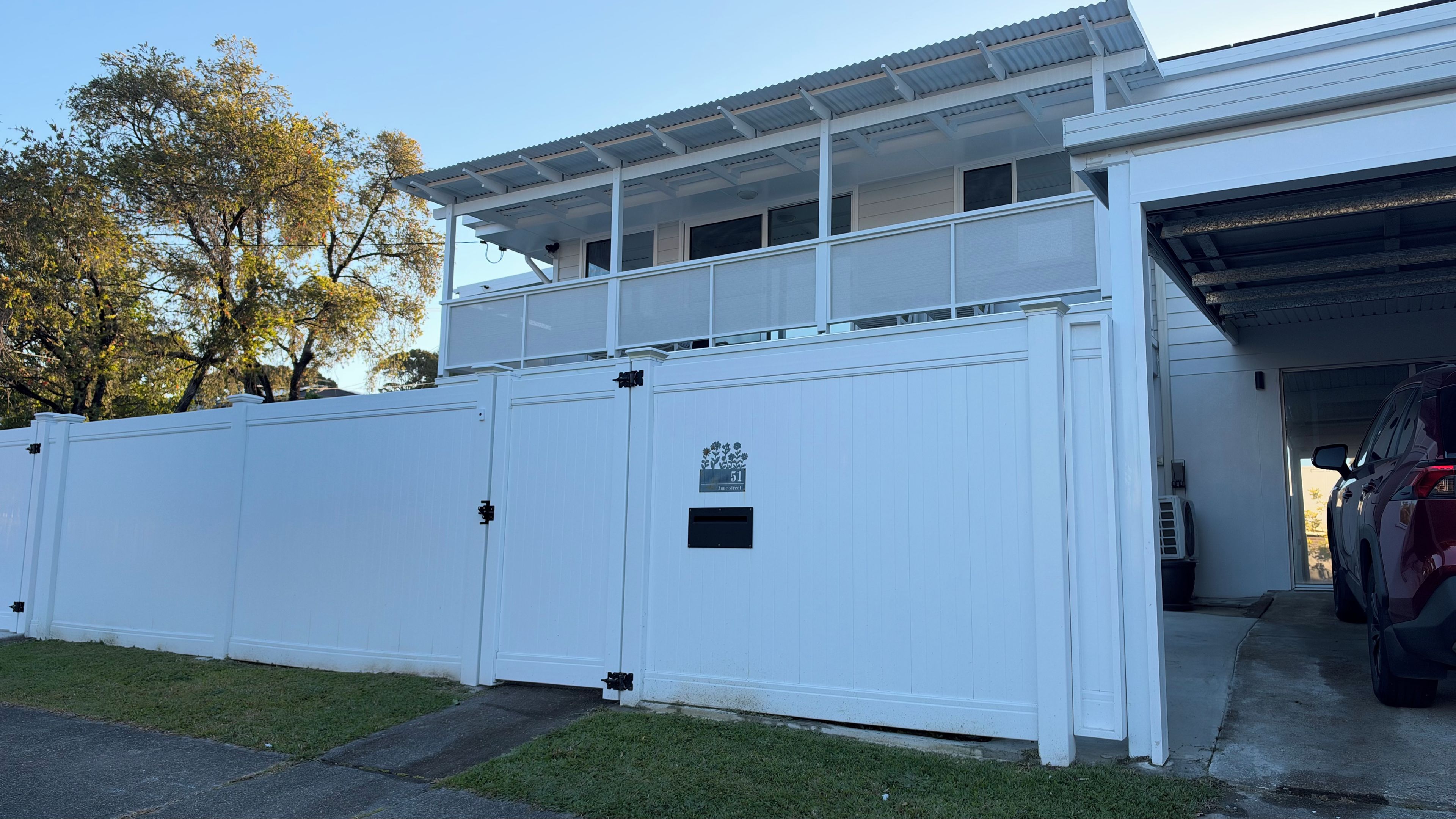 A white building with a garage door, a mailbox, and a sign with the number 51.