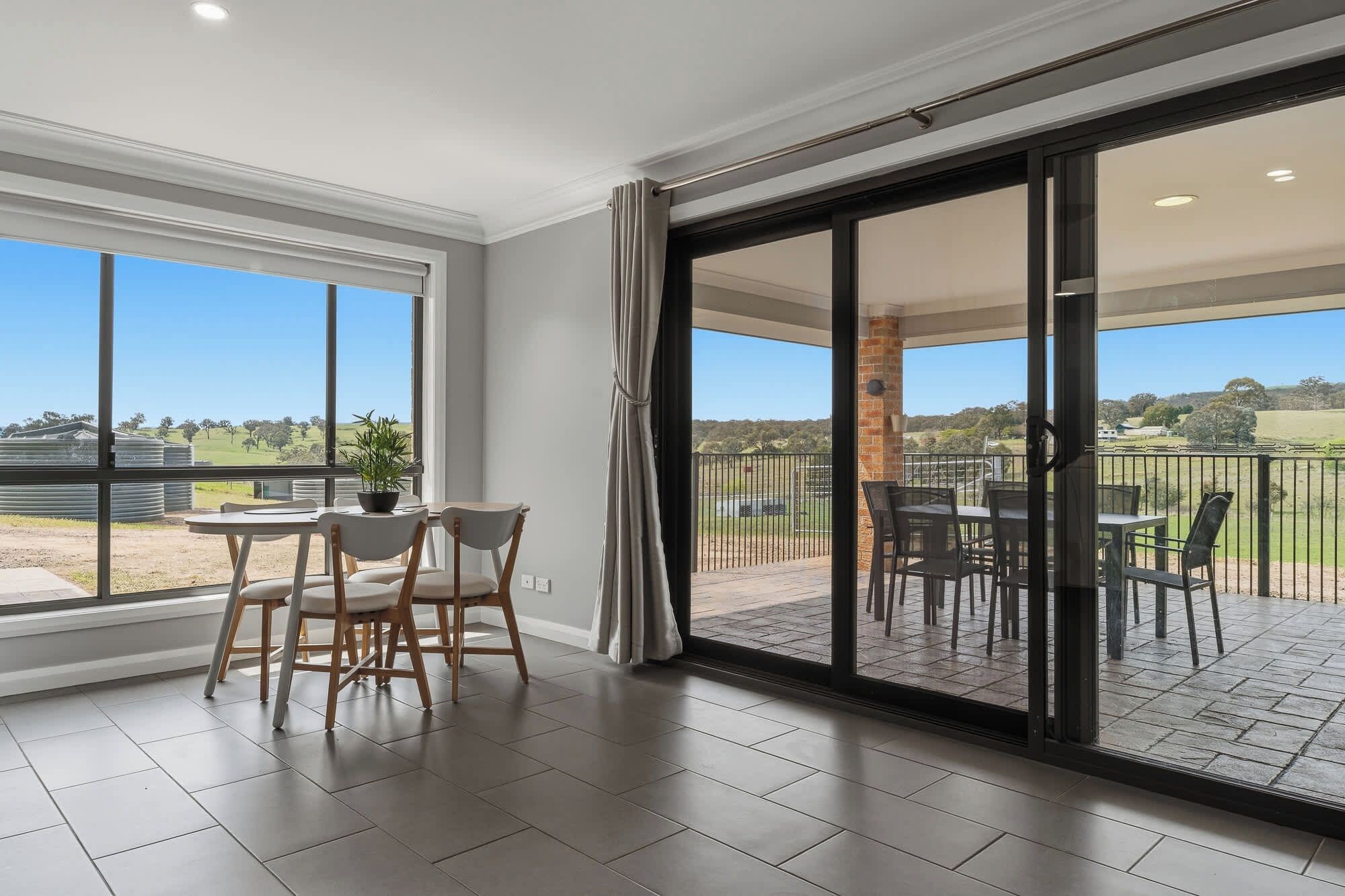 A spacious room with a large sliding glass door leading to an outdoor patio area.