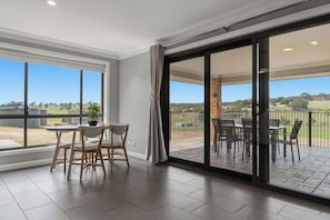 Een ruime kamer met een grote schuifpui naar een terras.