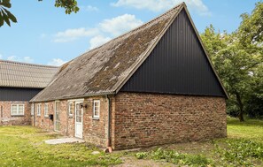 Un petit bâtiment en briques, doté d’un toit en pente et d’une porte.