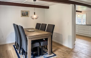 A dining area with a wooden table and chairs, a hanging light fixture, and a patterned rug. - Gorgeous home in Skærbæk with WiFi (Skærbæk)