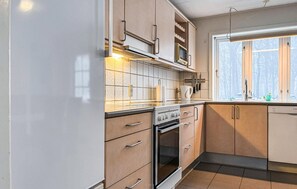 Eine Küche mit Herd, Backofen, Mikrowelle und Schränken.