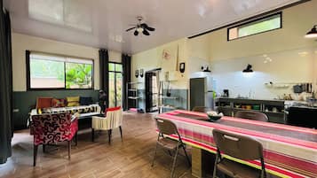Una cocina amplia con zona de comedor, suelo de madera y ventilador de techo.