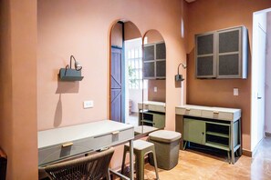 A room with a desk, chair, and a mirror. There is a window with a view outside. - w* | Deluxe 4BR in Prime Bocagrande (Cartagena de Indias)