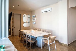 A dining area with a marble table, six chairs, and a large mirror on the wall. - w* | Deluxe 4BR in Prime Bocagrande (Cartagena de Indias)