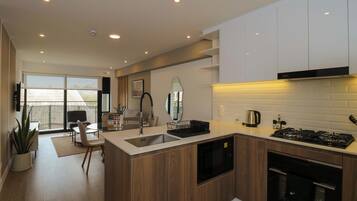 A modern kitchen with a central island, built-in appliances, and a dining area with a view.
