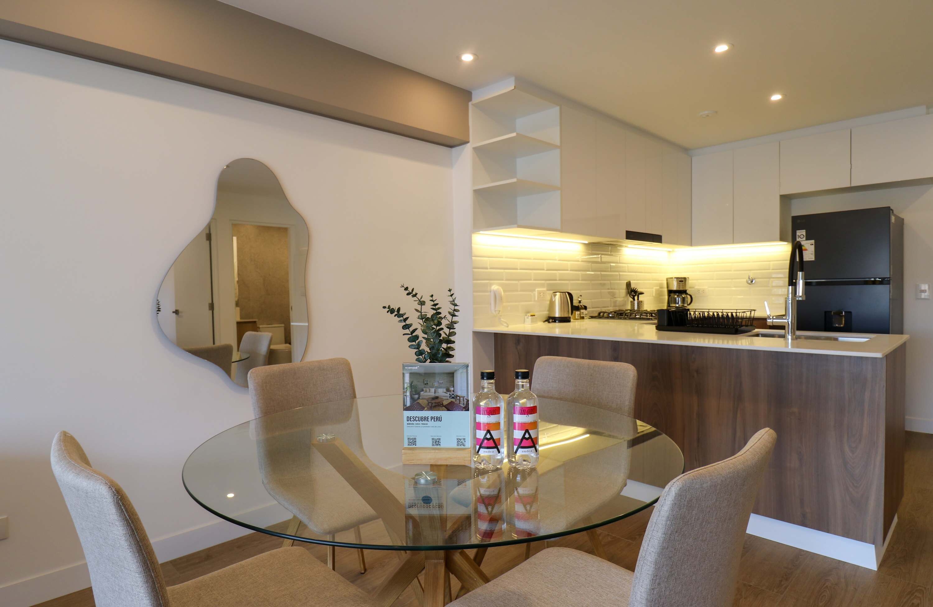 A modern kitchen with a black refrigerator, a coffee machine, and a sink.
