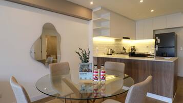 A modern kitchen with a black refrigerator, a coffee machine, and a sink.