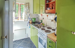 A kitchen with a stove, sink, and green cabinets. - Cozy home in Visby with ethernet internet (Visby)