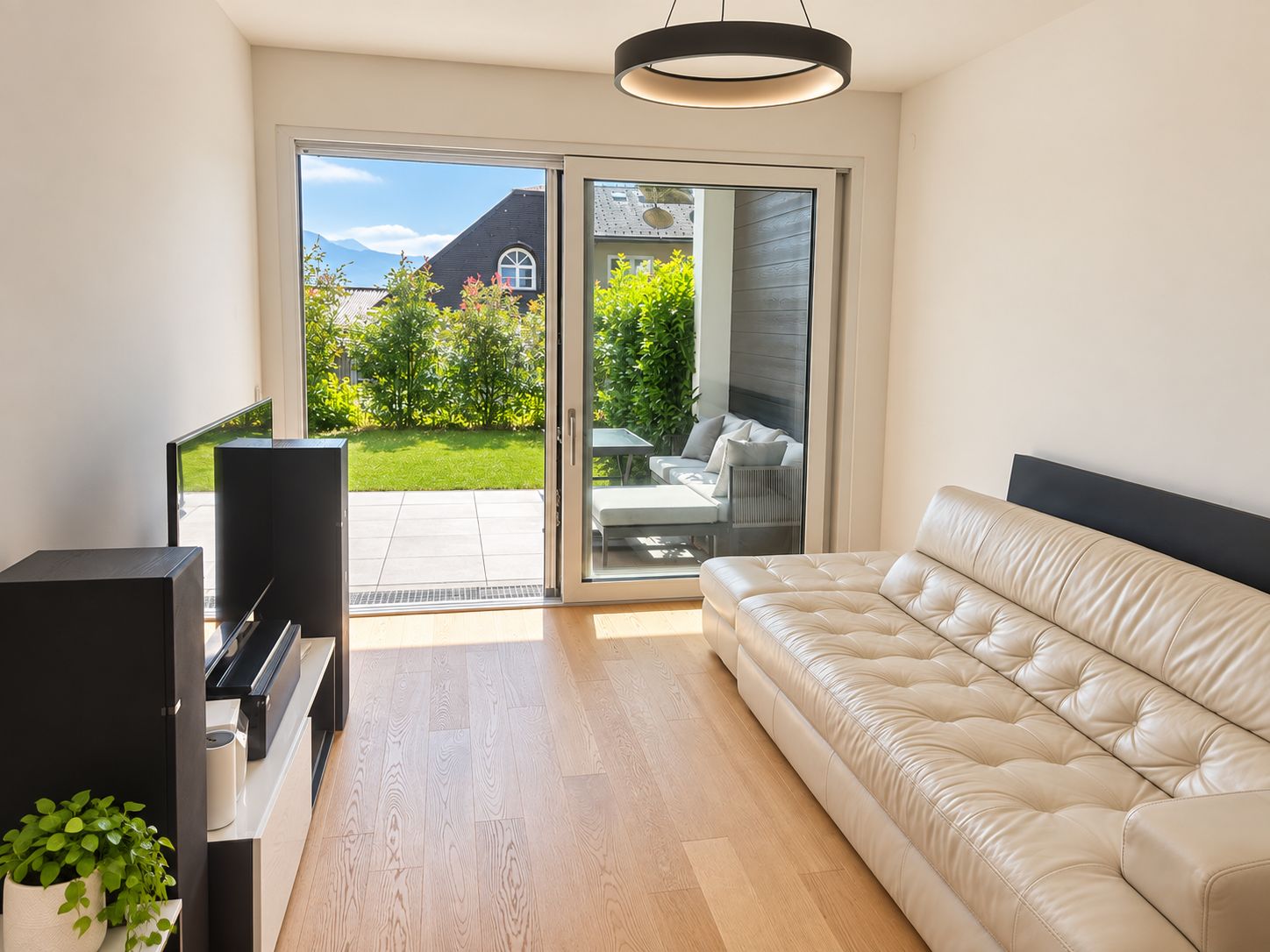 Ein modernes Wohnzimmer mit einer Couch, einem Fernseher und einem Klavier.