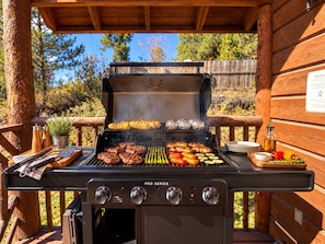 An outdoor grill with multiple cooking options, including a grill rack, a flat top, and a side burner. - Hot Tub | 32 Miles to Yellowstone | Fire Pit (Island Park)
