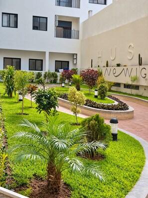A landscaped courtyard with a variety of plants and a building with a sign that reads 'HUS NEWWIG'. - AS29 Moroccan Charm Downtown / Free Parking / Wi-Fi (Casablanca)
