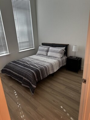 Ein Schlafzimmer mit Bett, Nachttisch und Fensterläden.