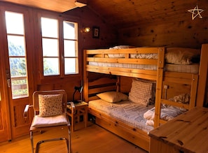 A wooden cabin room with a bunk bed, a chair, a desk, and a window. - Charming chalet near the funicular for 5-6 peopleOutside: detached chalet near the funicular with la (St-Luc)