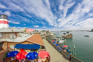 A pier with a restaurant named 'Friendly Fisherman Restaurant' and a lighthouse in the background. - 🌅 Madeira Bay 407 | Beach Getaway Just Steps from the Sand (Madeira Beach)