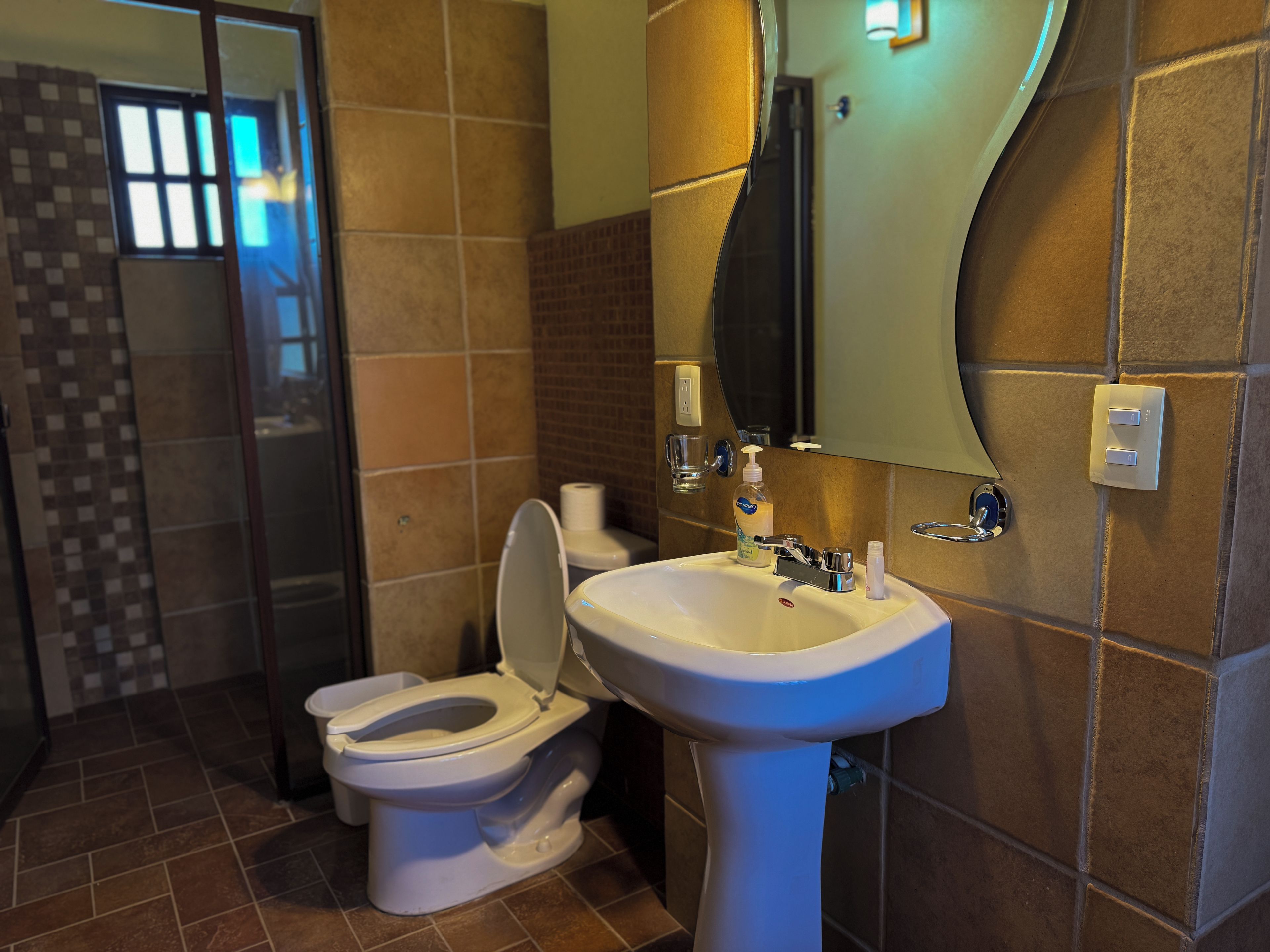 Un baño con inodoro, lavabo y espejo.