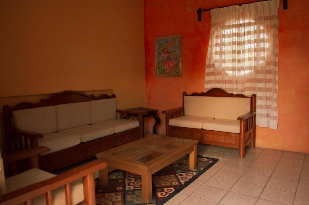 A living room with a sofa, a wooden coffee table, and a patterned rug.