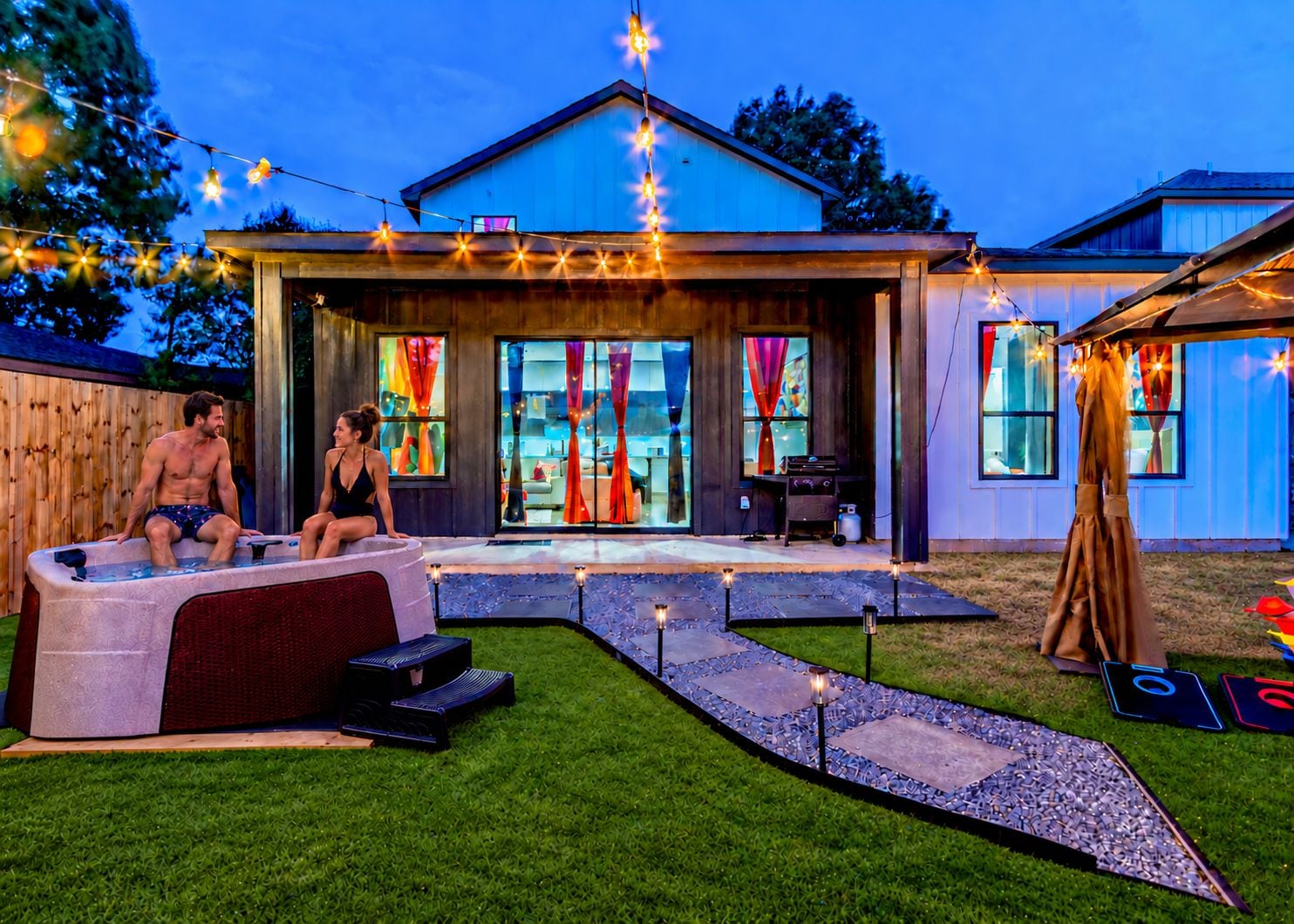 A backyard with a hot tub, outdoor seating, and a patio area.