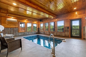 Une cabane en bois avec une piscine, de grandes fenêtres et une vue sur l’extérieur.