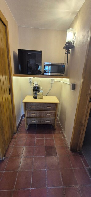 A small kitchenette with a microwave, a coffee maker, and a wall-mounted light fixture. - Sandy Shores 5A (La Paz)