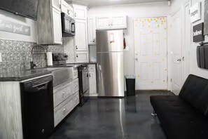 A kitchen with white cabinets, a stainless steel refrigerator, and a black dishwasher. - Destination Red Raiderland - Walk to TTU - 2BR/2BA (Lubbock)