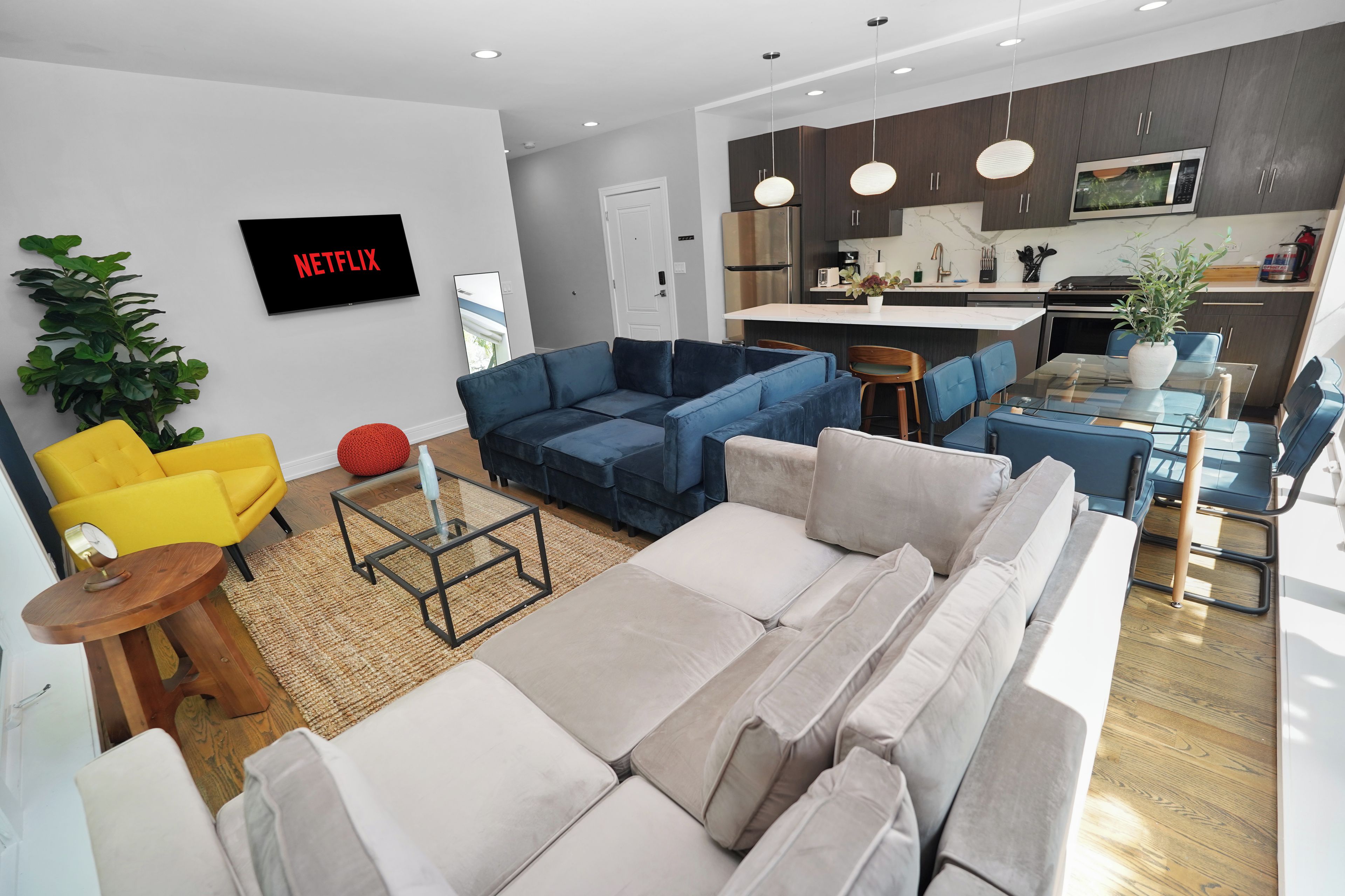 A modern living room with a sofa, a coffee table, and a TV mounted on the wall.