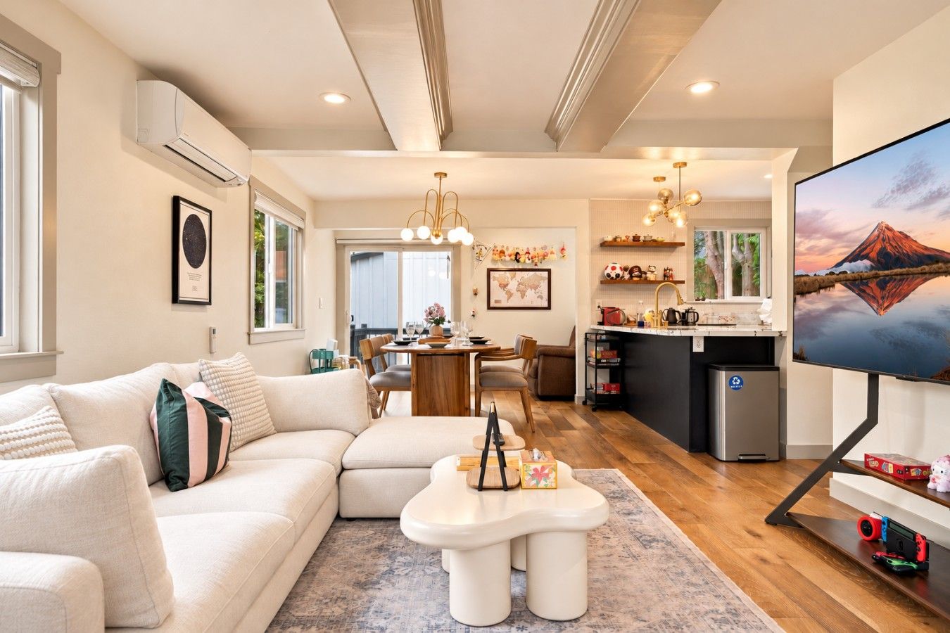 A modern living room with a sofa, coffee table, and a TV on a stand.