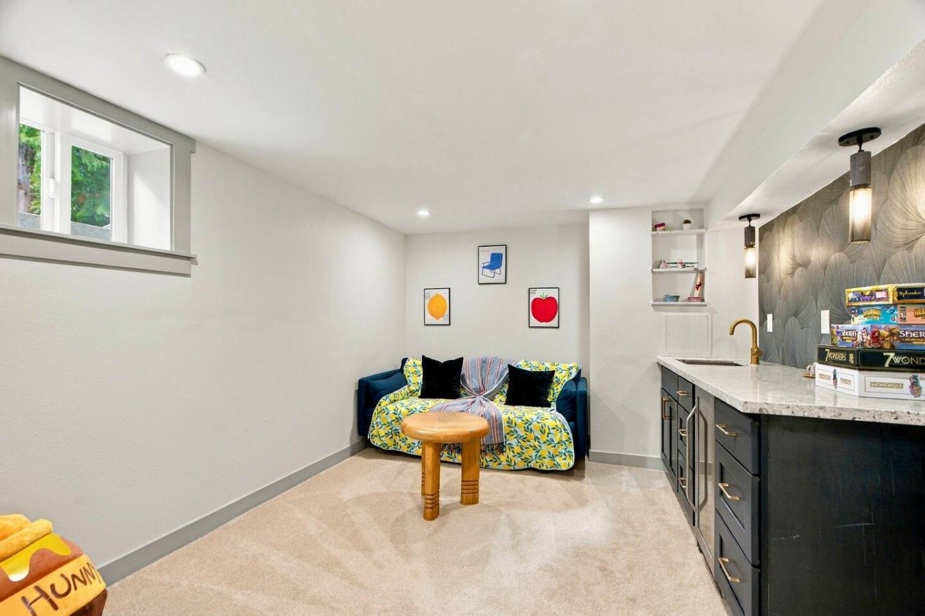 A compact living space with a kitchenette, a dining area with a small table, and a sofa with colorful cushions.
