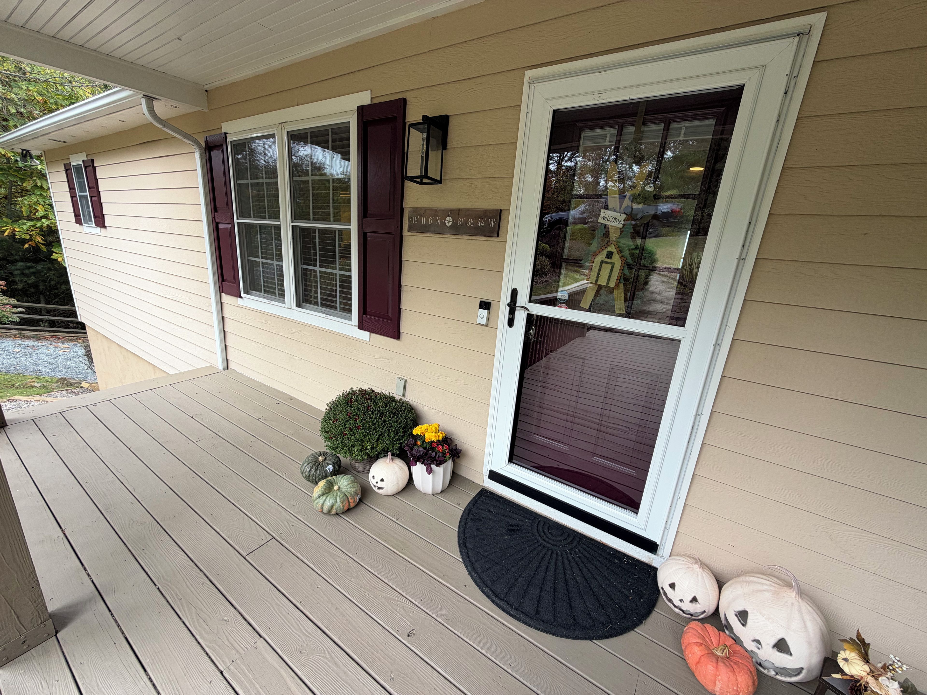 A house with a front porch, a mailbox, and a welcome sign.