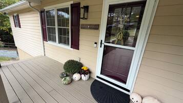 A house with a front porch, a mailbox, and a welcome sign.