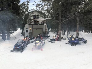A snowmobile storage area with several snowmobiles parked in front of a building. - Beautiful 5-bedroom cabin perfect for your Island Park or Yellowstone getaway (Island Park)