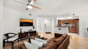 A modern living room with a brown leather sofa, a wooden coffee table, and a television mounted on the wall. - Roadrunner Haven — warm and welcoming Monthly Rent (Scottsdale)