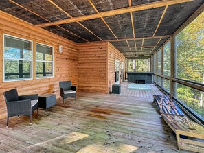 A wooden cabin with a porch, wicker furniture, and a hot tub. - Graceland - Dogs OK | Hot Tub | Game Room | EV Charger (Blue Ridge)