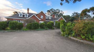 A two-story brick house with a driveway and well-maintained landscaping.