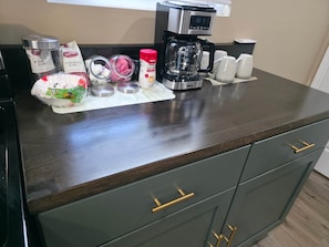 A kitchen counter with a coffee maker, jars, and a coffee filter. - Your Home Away From Home- Private Oasis (Wichita)