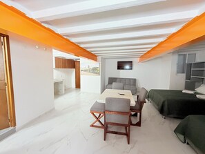 Ein modernes Interieur mit Essbereich, einer Couch und einem Bett.