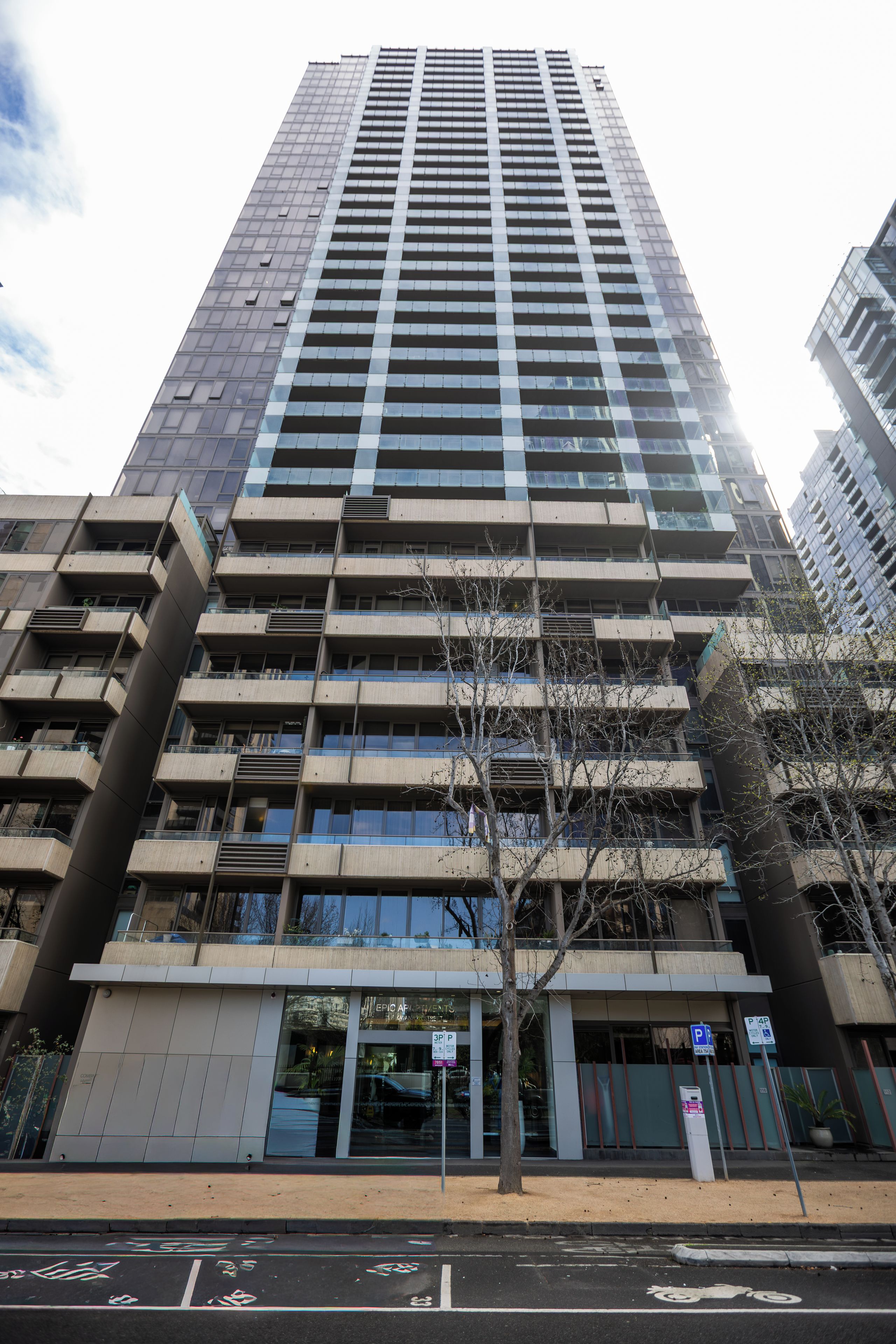 A high-rise building with multiple floors, large windows, and a ground-level entrance.
