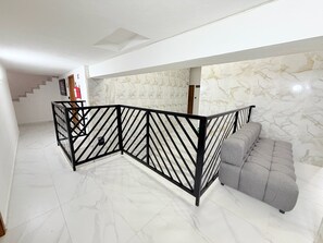 A modern interior with a marble floor, a grey sofa, and a black metal partition. - Cathedral Centro Histórico D14 (Guadalajara)